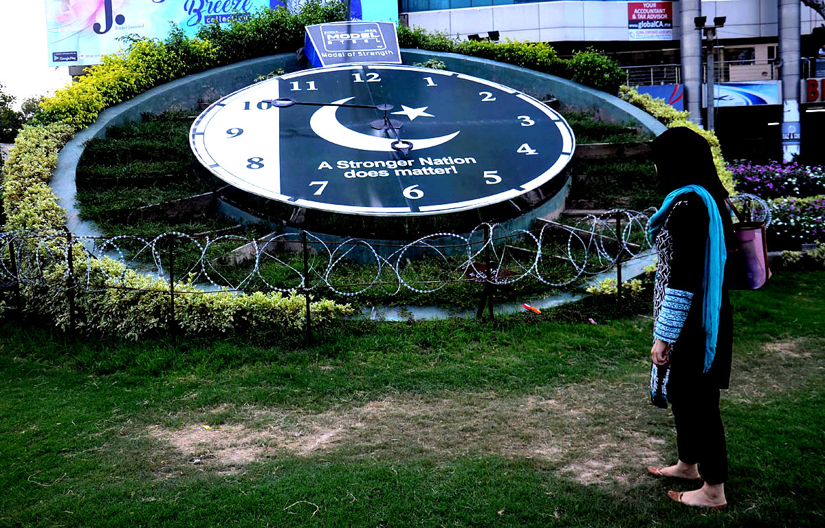 LAHORE: Woman Looks At Huge Clock Displaying National Flag At Liberty Chowk