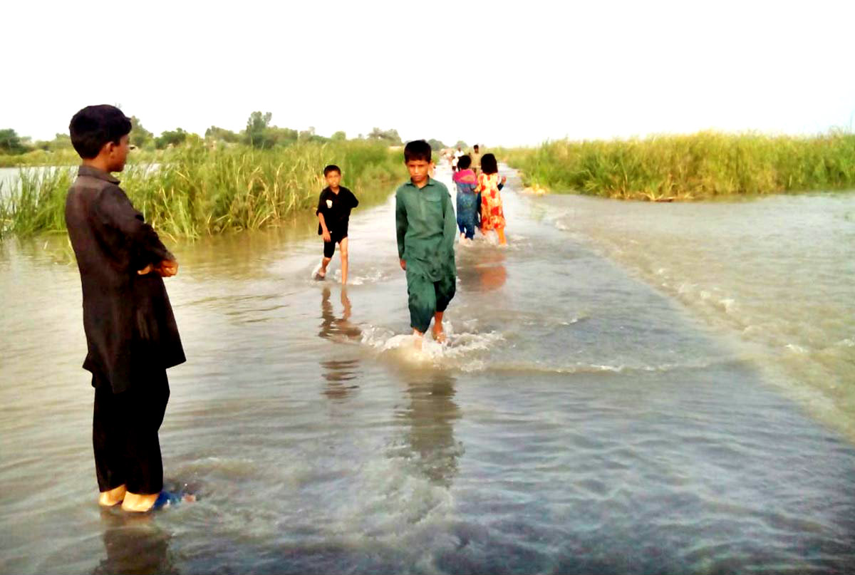 DERAALLAHYAR Children wade through water entering a village