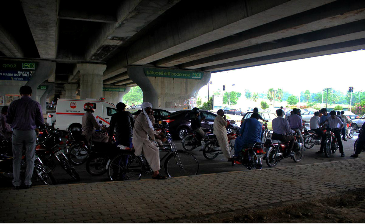 Islamabad Motorcyclists Shelter Themselves Under A Bridge During Rain