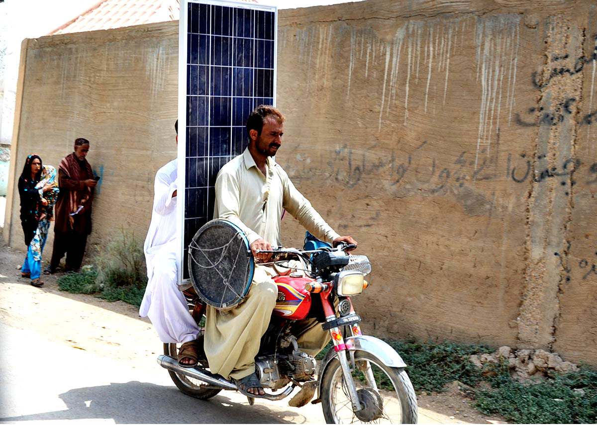 Men Seen Shifting A Solar Panel As People Face Electricity Shortage
