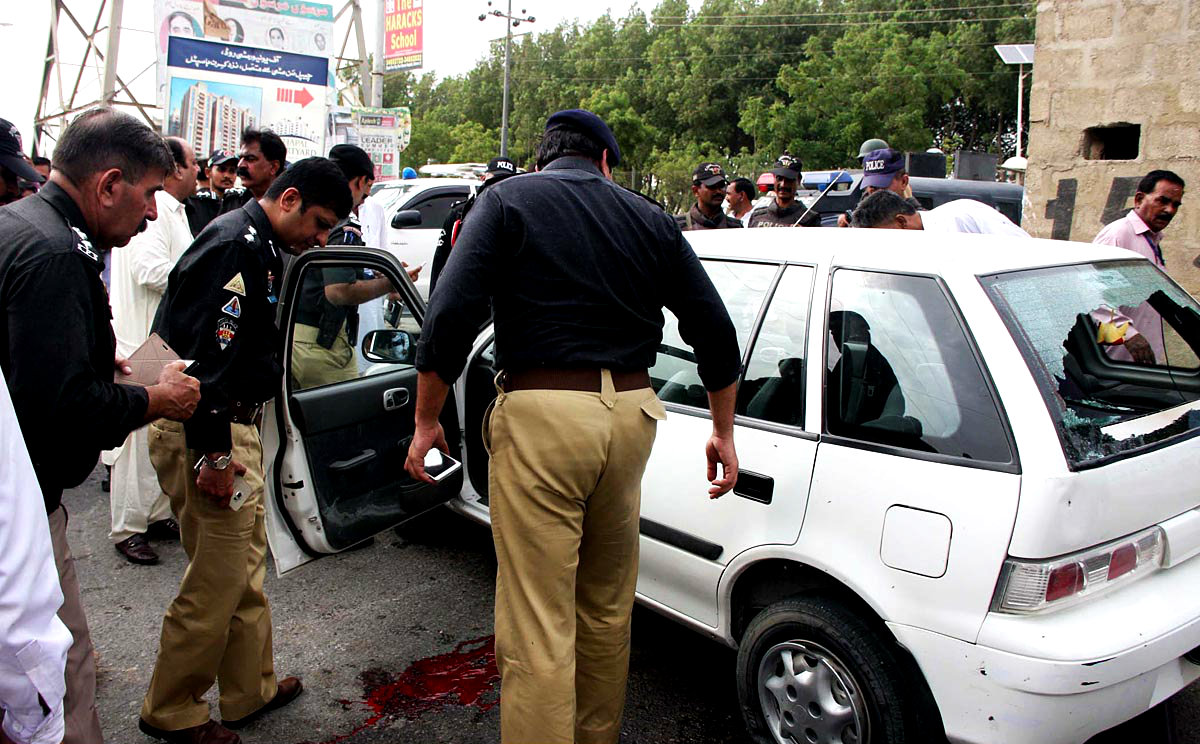 Karachi Security Personnel Examining Car Which Was Attacked By Unknown Gunmen