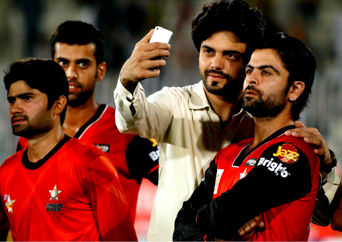 A Cricket Fan Taking Selfie With Cricketer Ahmad Shahzad After a match