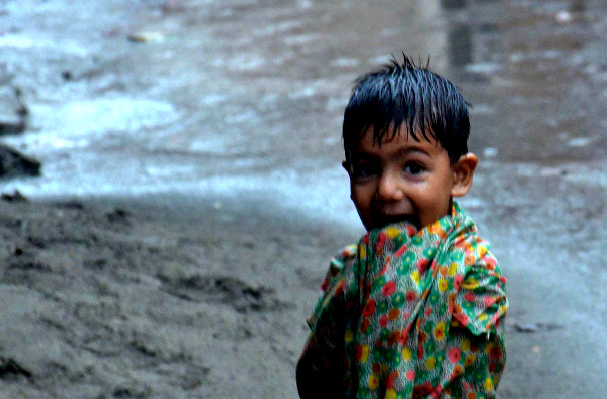 A Child Seen Enjoying In The Rain